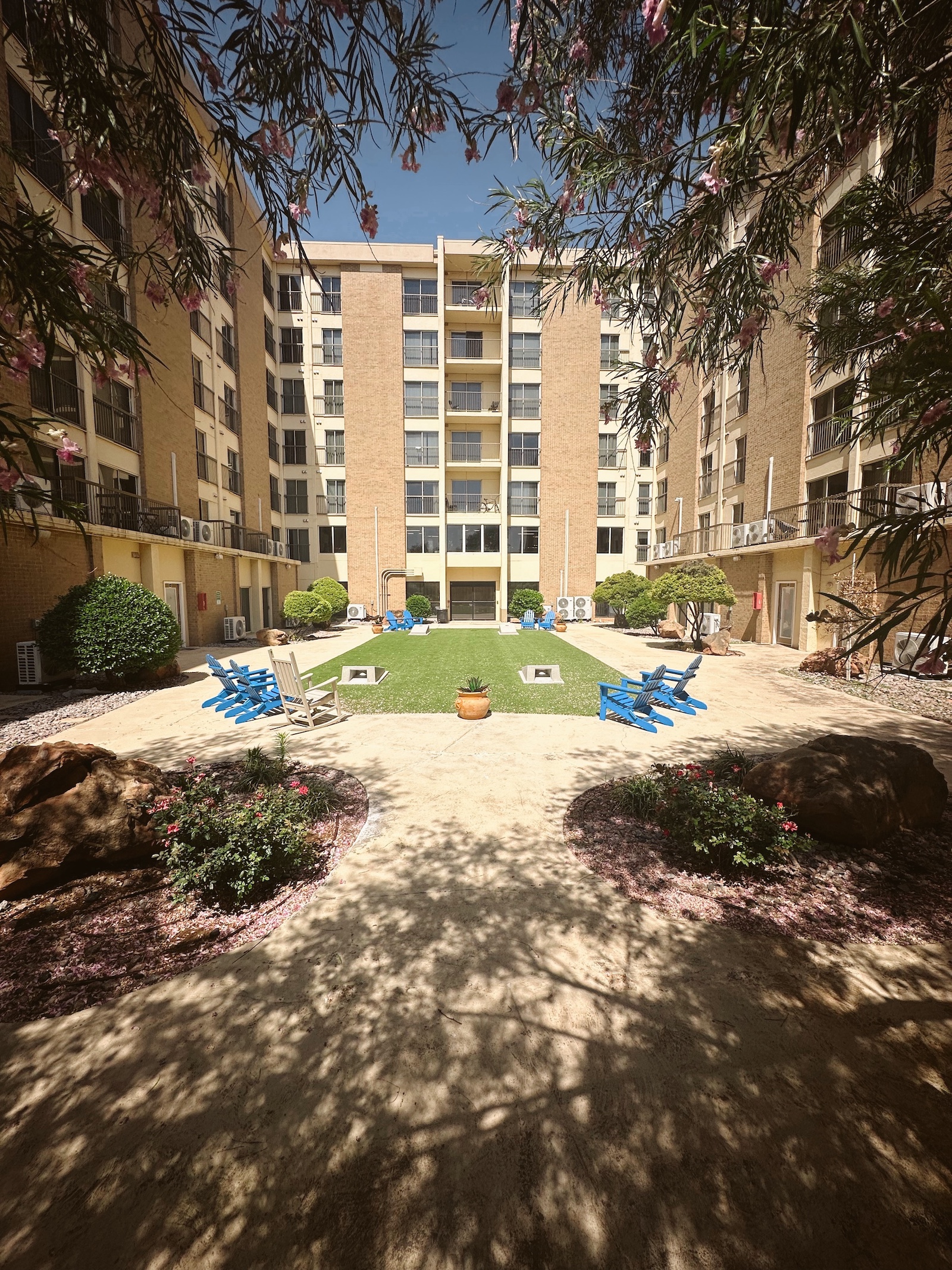 Courtyard with blue chairs and greenery